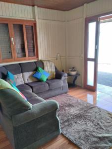 a living room with a couch and a rug at Pousada Flor da Serra in Urubici
