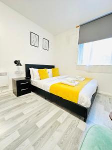 a bedroom with two beds with yellow pillows and a window at Private Studio Flat in City 1160 in London