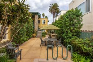 a patio with a table and chairs and an umbrella at Ocean Beach Pier Condo in San Diego