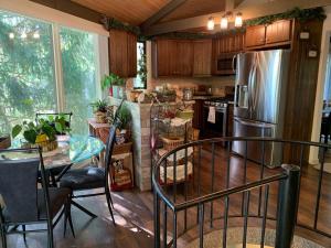 a kitchen with a table and a stainless steel refrigerator at Round Cabin - 5 Min to Bedford PA - Deck - Hike- Golf in Bedford