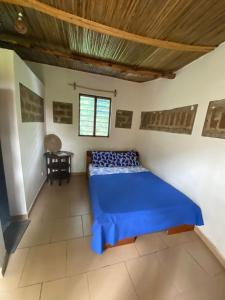 a bedroom with a blue bed and a table at Lodge au paradis fleuri 