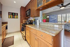 a kitchen with wooden cabinets and a counter top at Ocean Beach Pier Condo in San Diego