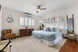 a bedroom with a canopy bed and a chair at Ocean Beach Pier Condo in San Diego