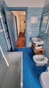 a bathroom with two sinks and a tub and a toilet at Vista sulla marina, AC, ascensore in Savona +40 photos
