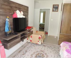 sala de estar con TV en una pared de madera en Sobrado super lindo a duas quadras praia., en Guaratuba