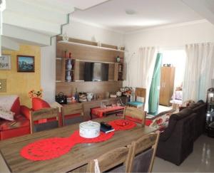 cocina y sala de estar con mesa de madera en Sobrado super lindo a duas quadras praia. en Guaratuba