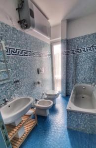 a bathroom with two toilets and a tub and a sink at Vista sulla marina, AC, ascensore in Savona