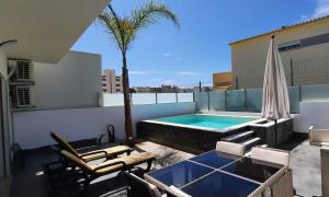 a patio with a swimming pool on top of a building at Lovely Home, WIFI, Jardim in Armação de Pêra