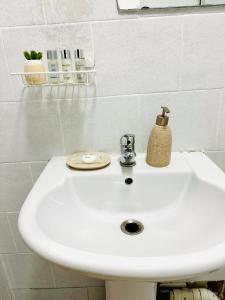 a white bathroom sink with a soap dispenser on it at Private Studio Flat in City 1160 in London