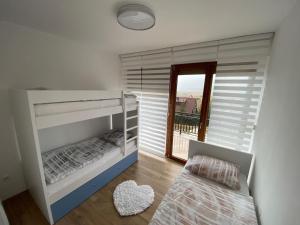 a bedroom with two bunk beds and a window at Apartman Anđela in Kupres