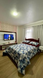 een slaapkamer met een bed met een blauw en wit dekbed bij Casa Bombinhas in Bombinhas