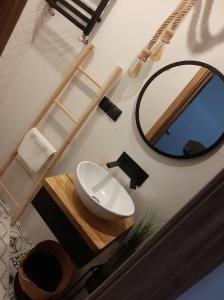 La salle de bains est pourvue d'un lavabo et d'un miroir. dans l'établissement Aparatment dla 4 osób numer 1, à Orzysz