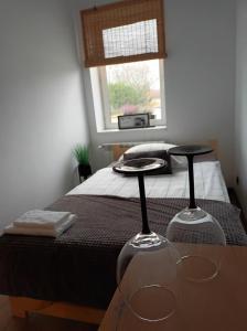 a bedroom with a bed with two wine glasses on a table at Aparatment dla 4 osób numer 1 in Orzysz