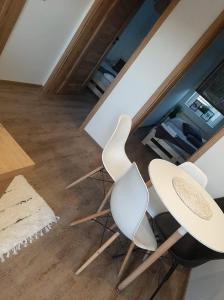 - deux chaises blanches et une table dans une pièce dans l'établissement Aparatment dla 4 osób numer 1, à Orzysz