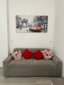 un sofá en una habitación con una foto de un tren en Appartamento comodo per Milano e Rho Fiera en Milán