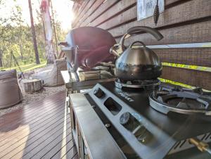 a tea kettle sitting on top of a stove at Ketchup's Bank Glamping in Boonah