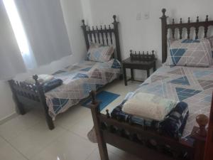 a bedroom with two beds and two tables at Ótimo Apartamento São Lourenço in São Lourenço