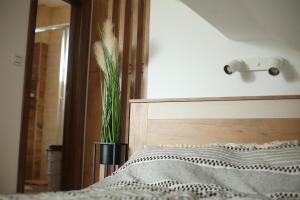 ein Schlafzimmer mit einem Bett und eine Vase mit einer Pflanze in der Unterkunft Start Apartments LUX KOPAONIK in Kopaonik