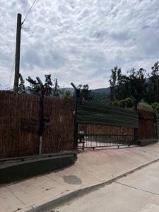 a wooden fence with a gate with a bench behind it at Cabaña 2 a 4 personas por dias in Olmué