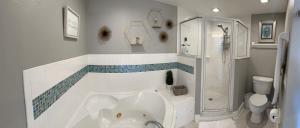 a bathroom with a tub and a shower and a toilet at Ocean Walk Beach and Sun New Smyrna Beach in New Smyrna Beach