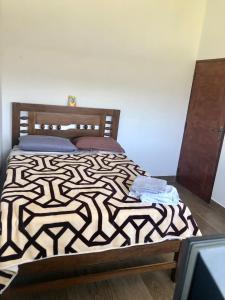 um quarto com uma cama com um edredão preto e branco em La Casona em Samaipata