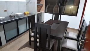 uma cozinha com um balcão, uma mesa e cadeiras em La Casona em Samaipata