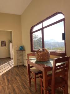 uma sala de jantar com uma mesa e cadeiras e uma janela em Cas-zaa em Teotitlán del Valle