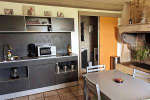 una cucina con tavolo e bancone con forno a microonde di Gîte Bohême a Donchery
