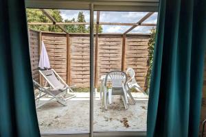 un patio con due sedie e un ombrellone di Gîte Bohême a Donchery