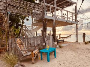 ein Haus am Strand mit einem Tisch und Stühlen in der Unterkunft Bluemare EcoHotel Frente a la playa Ensendada in Punta Rucia