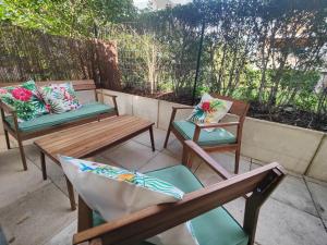 three wooden benches and chairs on a patio at QuietStay 20' PARIS, Connected HOME avec Terrasse in Massy