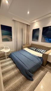 1 dormitorio con 1 cama grande y 1 silla en Boulevard Riviera Flat en Bertioga