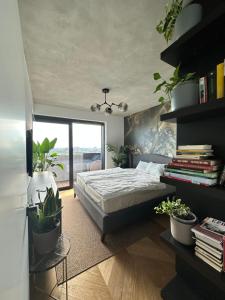 a bedroom with a bed and plants in it at Skyline elegance with free parking in Bratislava