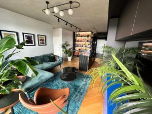 a living room with a green couch and lots of plants at Skyline elegance with free parking in Bratislava