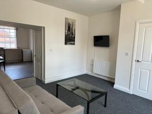 a living room with a couch and a glass coffee table at 1 Bed Central Newark Flat 1st Floor in Newark upon Trent
