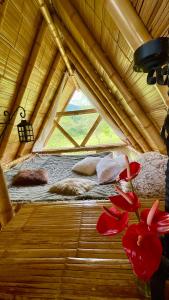 uma cama numa tenda com flores vermelhas no chão em Glamping La Herradura em Santa Rosa de Cabal