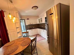 a kitchen with a table and a stainless steel refrigerator at GEORGIANA in Buzău