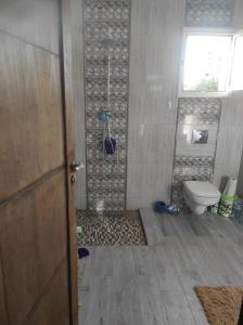 łazienka z prysznicem, toaletą i drzwiami w obiekcie maison spacieuse et lumineuse w mieście Hammamet Sud