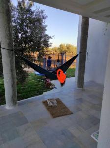 een paar mensen in een hangmat in een huis bij maison spacieuse et lumineuse in Hammamet Sud