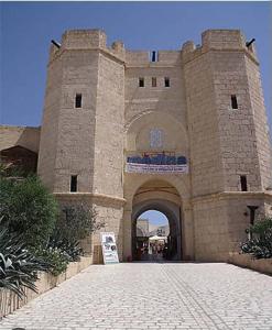 un grand bâtiment en briques avec un panneau devant lui dans l'établissement maison spacieuse et lumineuse, à Hammamet Sud
