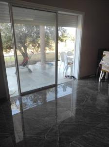 um quarto com uma porta de vidro deslizante e um pátio em maison spacieuse et lumineuse em Hammamet Sud