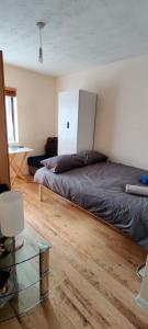 Schlafzimmer mit einem Bett und einem Glastisch in der Unterkunft Wembley house in London