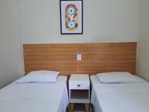 سرير أو أسرّة في غرفة في Hotel Oiticica