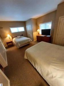 Cette chambre comprend 2 lits et une télévision à écran plat. dans l'établissement Golfers- Great condo for 4-6 people, à Bellaire