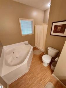 La salle de bains est pourvue d'une baignoire blanche et de toilettes. dans l'établissement Golfers- Great condo for 4-6 people, à Bellaire