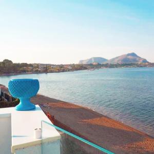 un jarrón azul sentado en una cornisa junto al agua en La Luna sul Mare, Sea-Luxury Rooms, en Casteldaccia