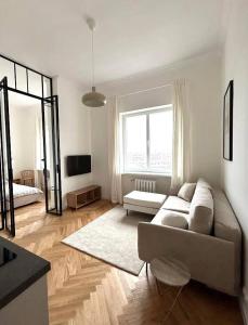 a living room with a couch and a large window at Old Town Residence , Wi-fi , 2-Beds , Aesthetics - by HIK Apartments in Warsaw