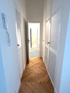 an empty hallway with white doors and a wooden floor at Old Town Residence , Wi-fi , 2-Beds , Aesthetics - by HIK Apartments in Warsaw