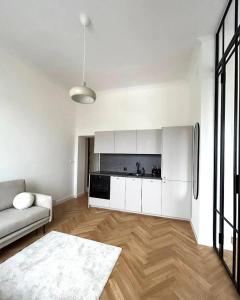 a white living room with a couch and a refrigerator at Old Town Residence , Wi-fi , 2-Beds , Aesthetics - by HIK Apartments in Warsaw