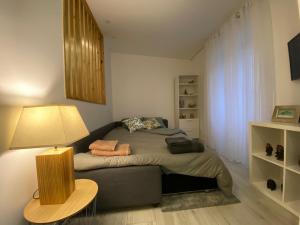 a small bedroom with a bed and a lamp at Urban 44 Guest House in Ponta Delgada